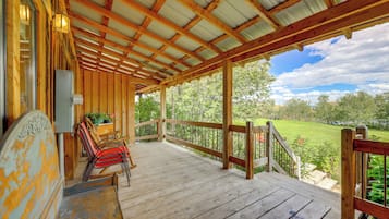 A wooden porch with a view of a green landscape.