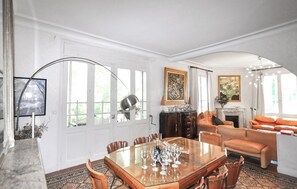 A spacious room with a large dining table surrounded by chairs, a fireplace, and a sofa. - Stunning home in Espira-de-l'Agly (Espira-de-l'Agly)