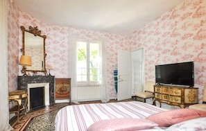 A bedroom with a bed, a television, a fireplace, and a window. - Stunning home in Espira-de-l'Agly (Espira-de-l'Agly)