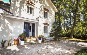 A two-story building with a white facade, a blue door, and a gravel driveway. - Stunning home in Espira-de-l'Agly (Espira-de-l'Agly)