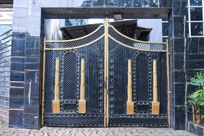 A black metal gate with decorative elements and rivets. - Townhouse Parkstreet FormerlyHotel Royal (Kolkata)