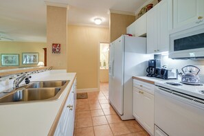 A kitchen with white cabinets, a stainless steel sink, a refrigerator, a coffee maker, and a toaster. - 1 Mi to Beach! Golfer’s Paradise on Pawleys Island (Pawleys Island)
