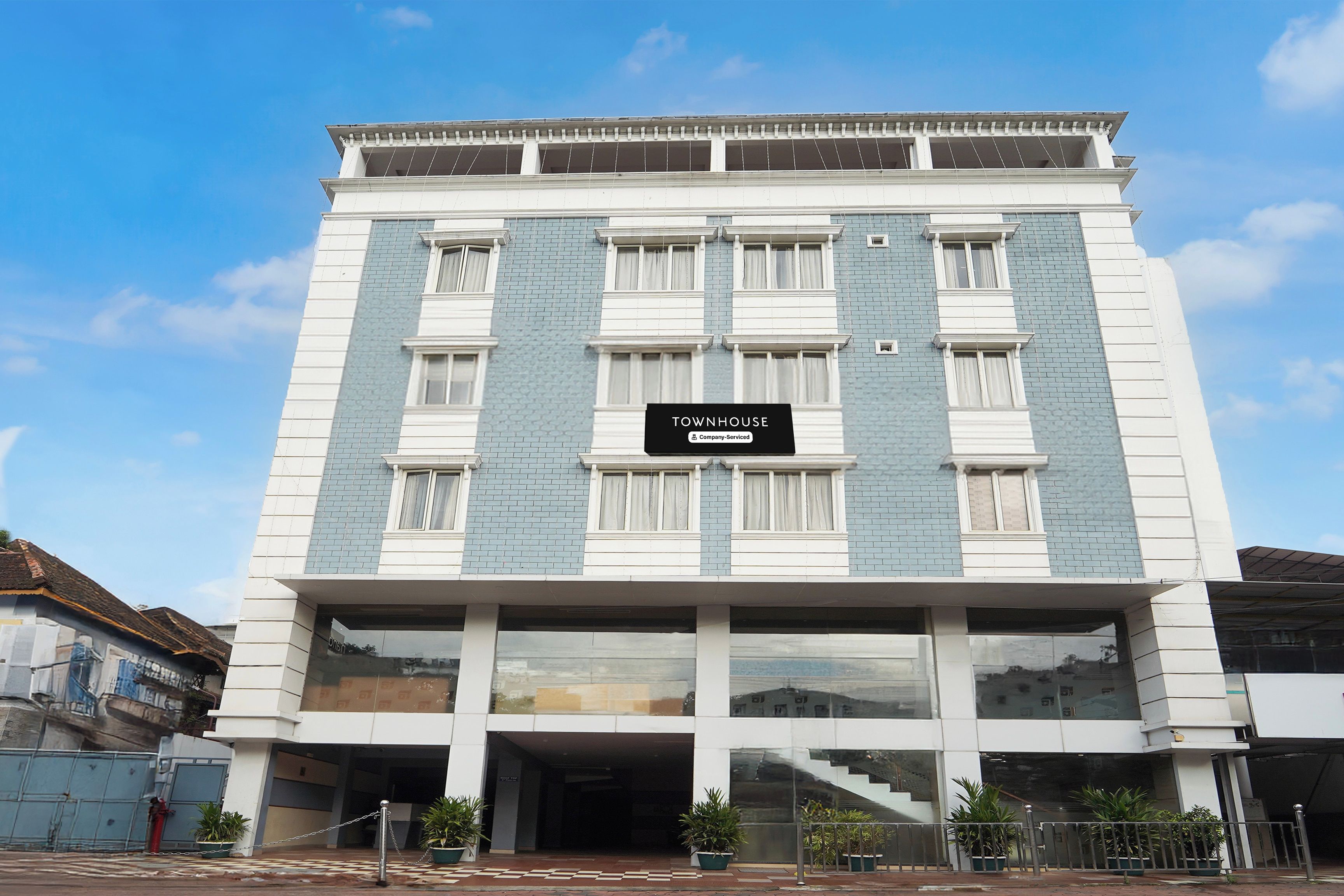 Un edificio de varios pisos con un letrero que indica que es una casa townhouse con servicios de empresa.