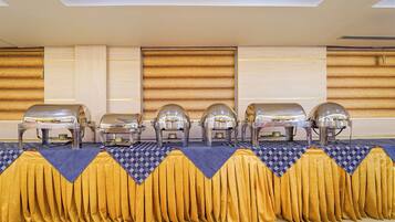 A buffet setup with multiple food stations and a checkered tablecloth.