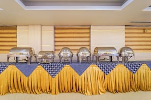 A buffet setup with multiple food stations and a checkered tablecloth.