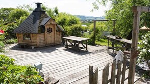 A wooden deck with a rustic wooden structure, a table, and a bench. - Holiday apartment with 1 bedroom (Oberkirch, Deutschland)