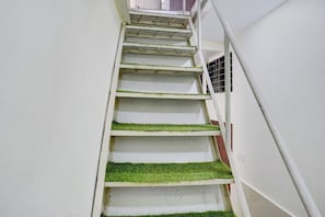 A staircase with white walls and green artificial grass steps. - Hotel O Jagruti Nagar Ghatkopar (Mumbai)