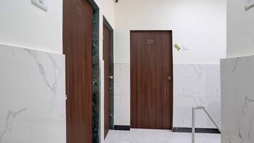 A hallway with marble walls and two wooden doors, one marked with the number 107 and the other with 105.