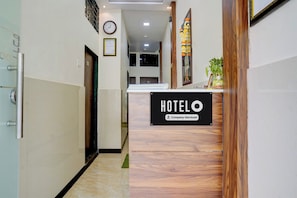 Un comptoir d’accueil d’hôtel avec une pancarte indiquant qu’il est géré par l’entreprise.