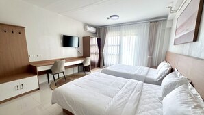Une chambre d’hôtel équipée d’un lit, d’un bureau, d’une chaise, d’une télévision et d’une armoire.