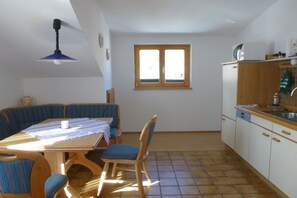 Uma cozinha compacta com área de refeições, janela e ventilador de teto.