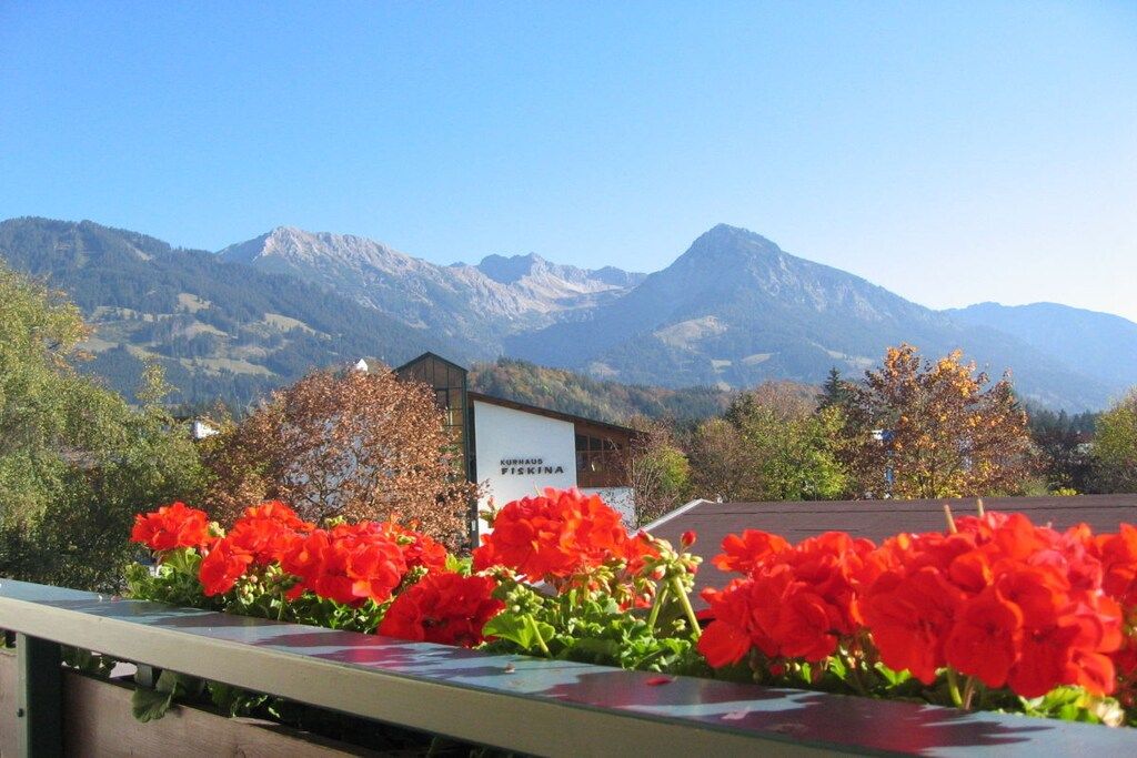 A mountain view with a building labeled 'KURHAUS FISKA' and red flowers in the foreground.