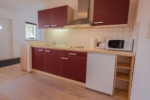 A compact kitchen with a sink, microwave, and white dishwasher. - Holiday apartment with 1 bedroom (Karlshagen)