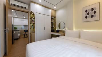 Un dormitorio moderno con una cama grande, un escritorio con una computadora portátil, un espejo y una estantería.