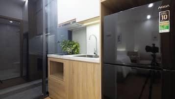 Una cocina moderna con lavavajillas integrado, un refrigerador de acero inoxidable y una encimera de madera.