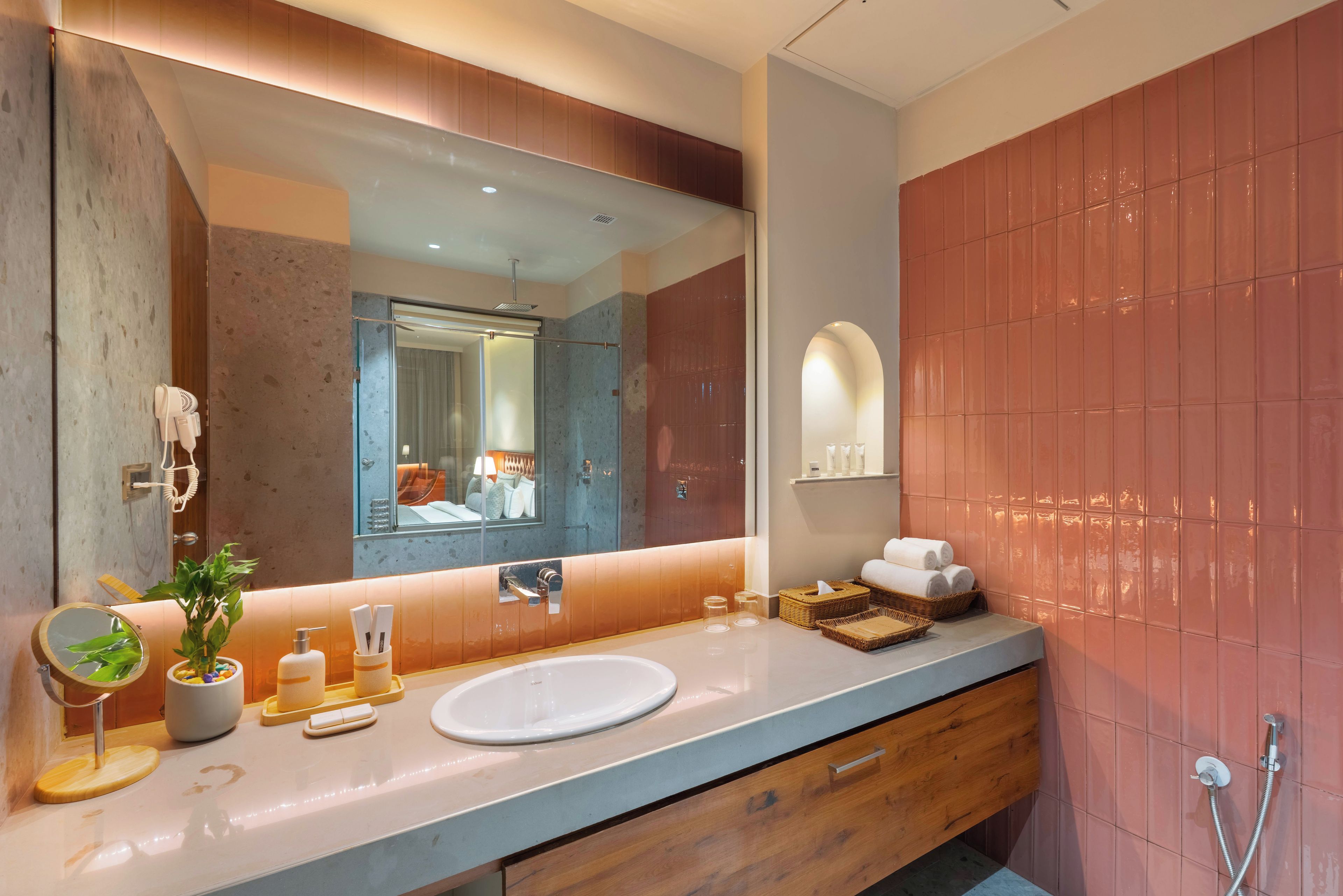 A modern bathroom with a large mirror, a sink, and a shower area.