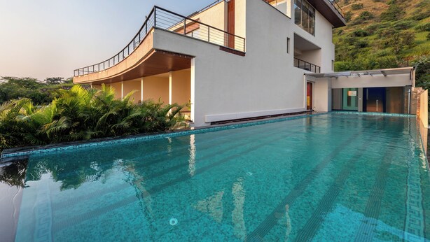 A modern two-story building with a swimming pool in front. - Traavista Rivera The Lake House (Panwari)