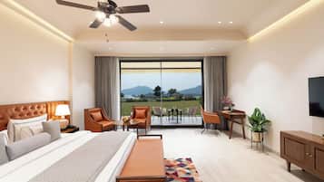 Habitación de hotel moderna con una cama grande, un escritorio, una silla, un televisor y un balcón con vista a las montañas.