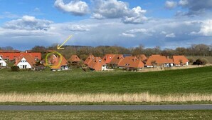 A residential area with houses, a road, and a grassy field. - Holiday home with 3 bedrooms (Wurster Nordseeküste)