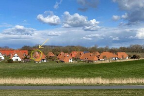 A residential area with houses, a road, and a grassy field. - Holiday home with 3 bedrooms (Wurster Nordseeküste)