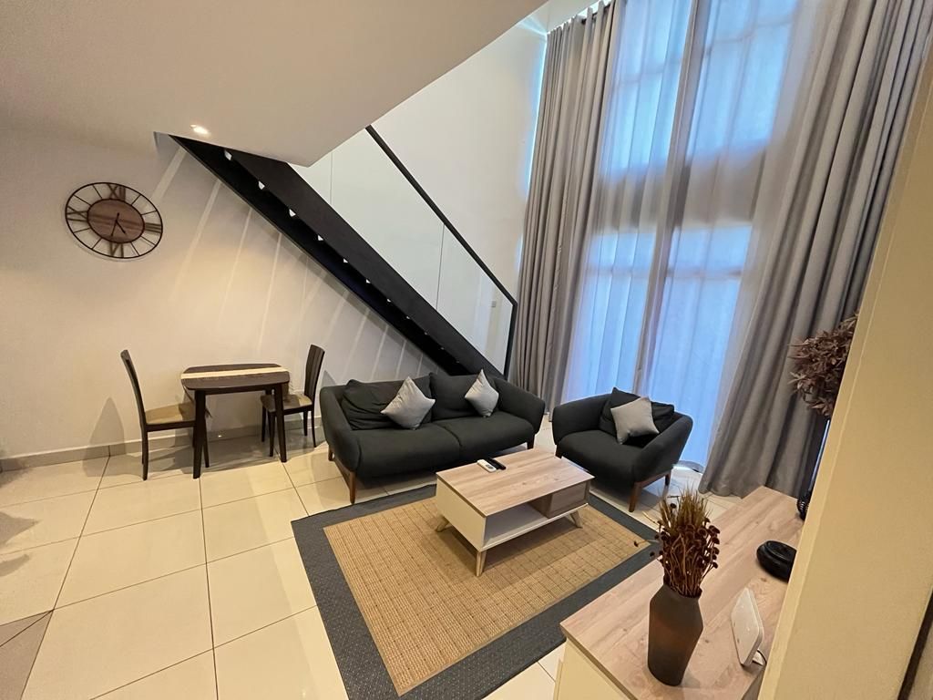 Una sala moderna con un conjunto de sofá, una mesa de centro y un comedor con sillas.