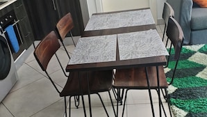 Un comedor con mesa y sillas, una cocina con armarios y una sala de estar con sofá y alfombra.