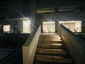 Una scala conduce all'ingresso di un edificio con il numero '3', un'area recintata e una piccola finestra.