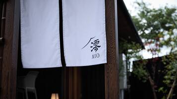 A white cloth with Japanese characters and the word 'MIO' hanging on a wooden structure.