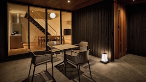 A modern interior with a dining area, a staircase, and a view into another room. - tuuli YUFU Kinrinko (Yufu)