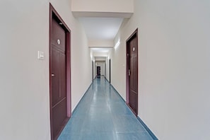 Un pasillo largo y estrecho con puertas a ambos lados, con los números 4 y 6, que conduce a habitaciones.
