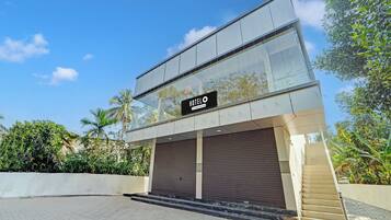 A modern hotel with a glass facade, a sign reading 'HOTEL', and a covered entrance.