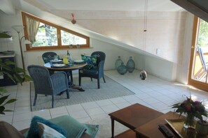 Uma área de refeições com mesa, cadeiras e janela.