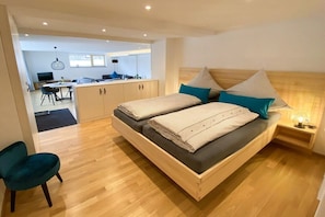 Quarto moderno com cama de madeira, escrivaninha e cadeira.