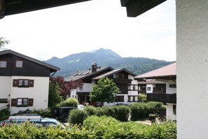 Ein Wohngebiet mit Häusern, einem Berg im Hintergrund und einem geparkten Auto im Vordergrund.