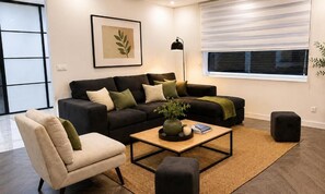 A living room with a sofa, armchair, coffee table, and a floor lamp. - Villa-Sylla - Nancy (Jarville-la-Malgrange)