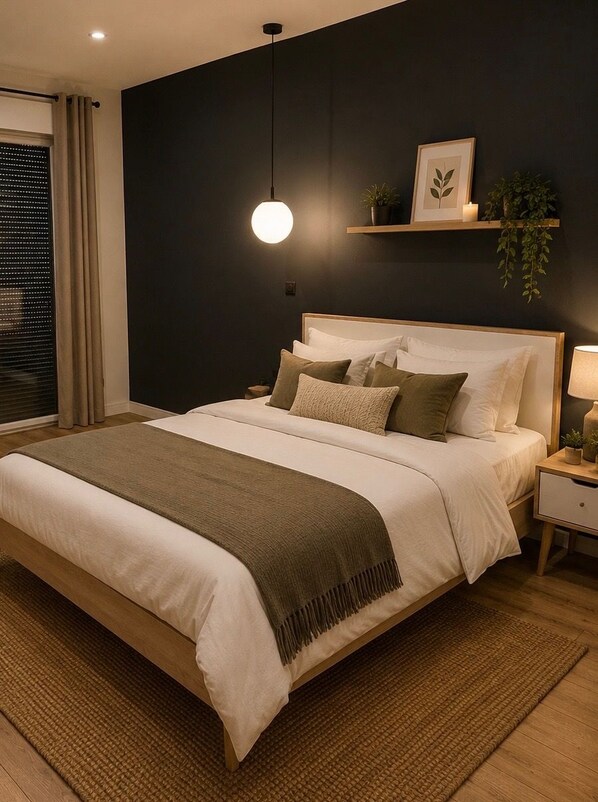 A modern bedroom with a large bed, bedside tables, a hanging light, and a dark wall.