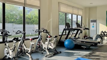 A gym with stationary bikes, a treadmill, and exercise balls.