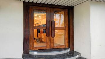 Une porte en bois avec des panneaux de verre et un escalier menant à cette porte.
