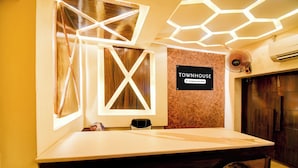 A reception desk with a sign that reads 'TOWNHOUSE' and a company-serviced label. - Super OYO Townhouse Varanasi Railway (Varanasi)