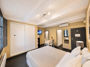 A hotel room with a bed, a television, a desk with a chair, and a wardrobe. - Ersextius, LGLL2, Aix-en-Provence (Aix-en-Provence)
