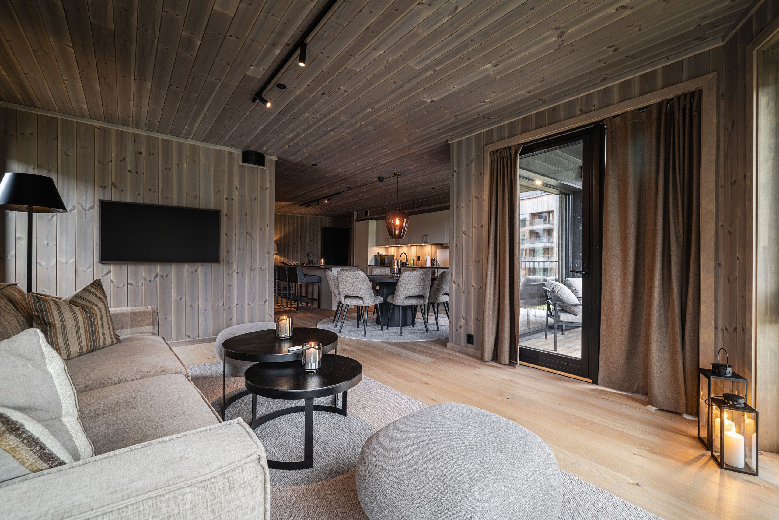 A modern living room with a sofa, a coffee table, and a TV mounted on the wall.