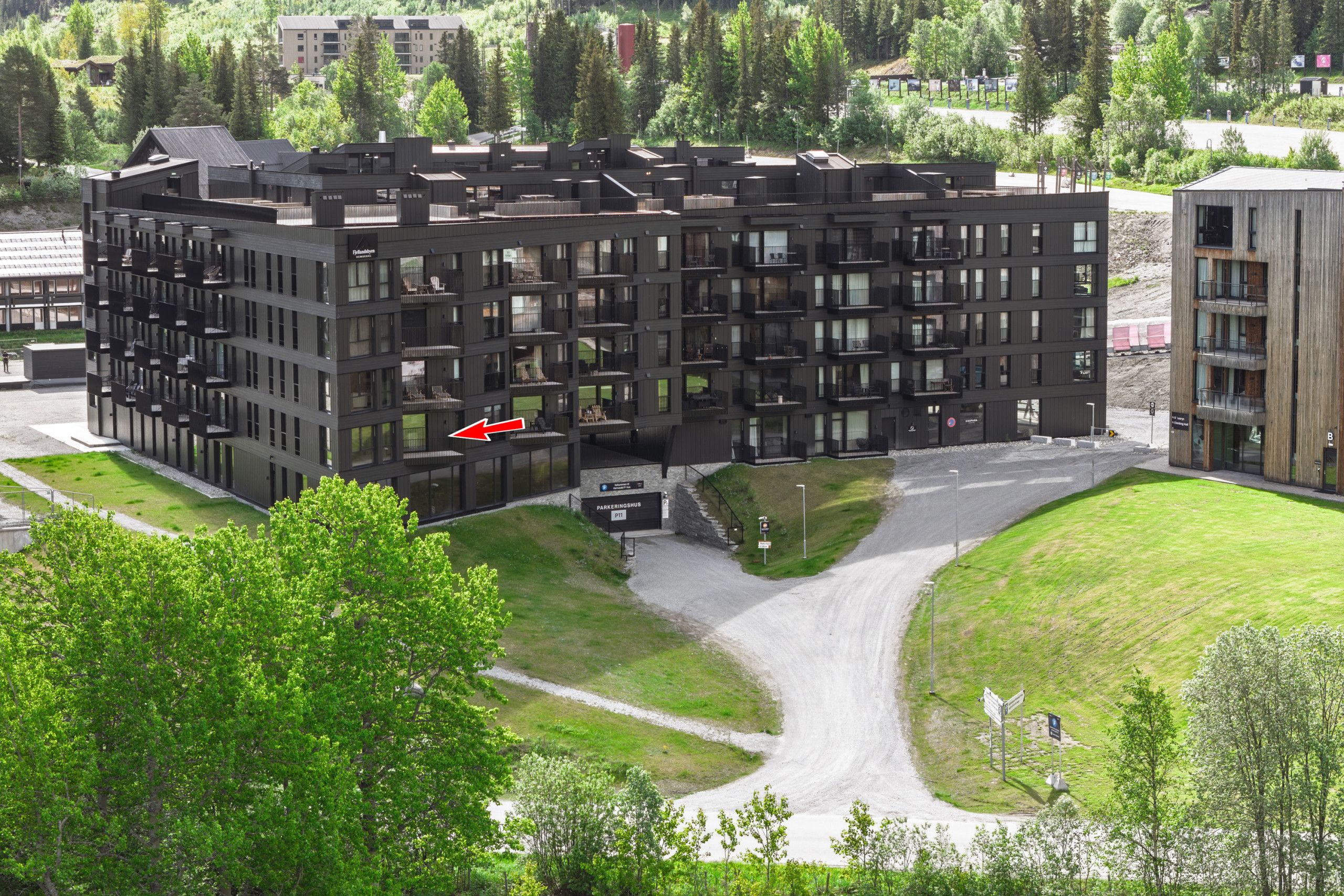 A multi-story building with a modern architectural design, featuring balconies and large windows.