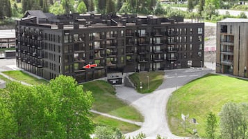 A multi-story building with a modern architectural design, featuring balconies and large windows.