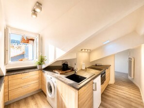 A modern kitchen with a built-in washing machine, a sink, and a window overlooking a cityscape. - Ersextius, GGB3, Nice (Nice)