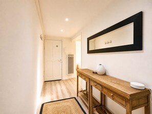 A hallway with a wooden console table, a mirror, and a door. - Ersextius, GGB3, Nice (Nice)