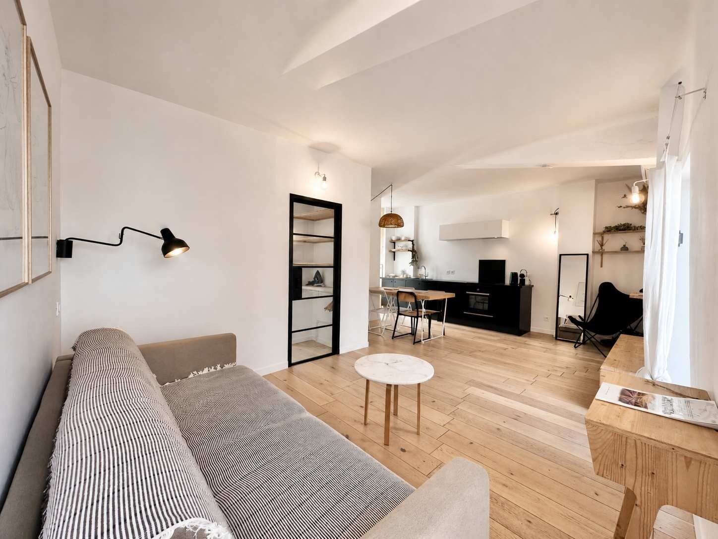 Ein moderner Wohnbereich mit Sofa, Esstisch und Küchenzeile.