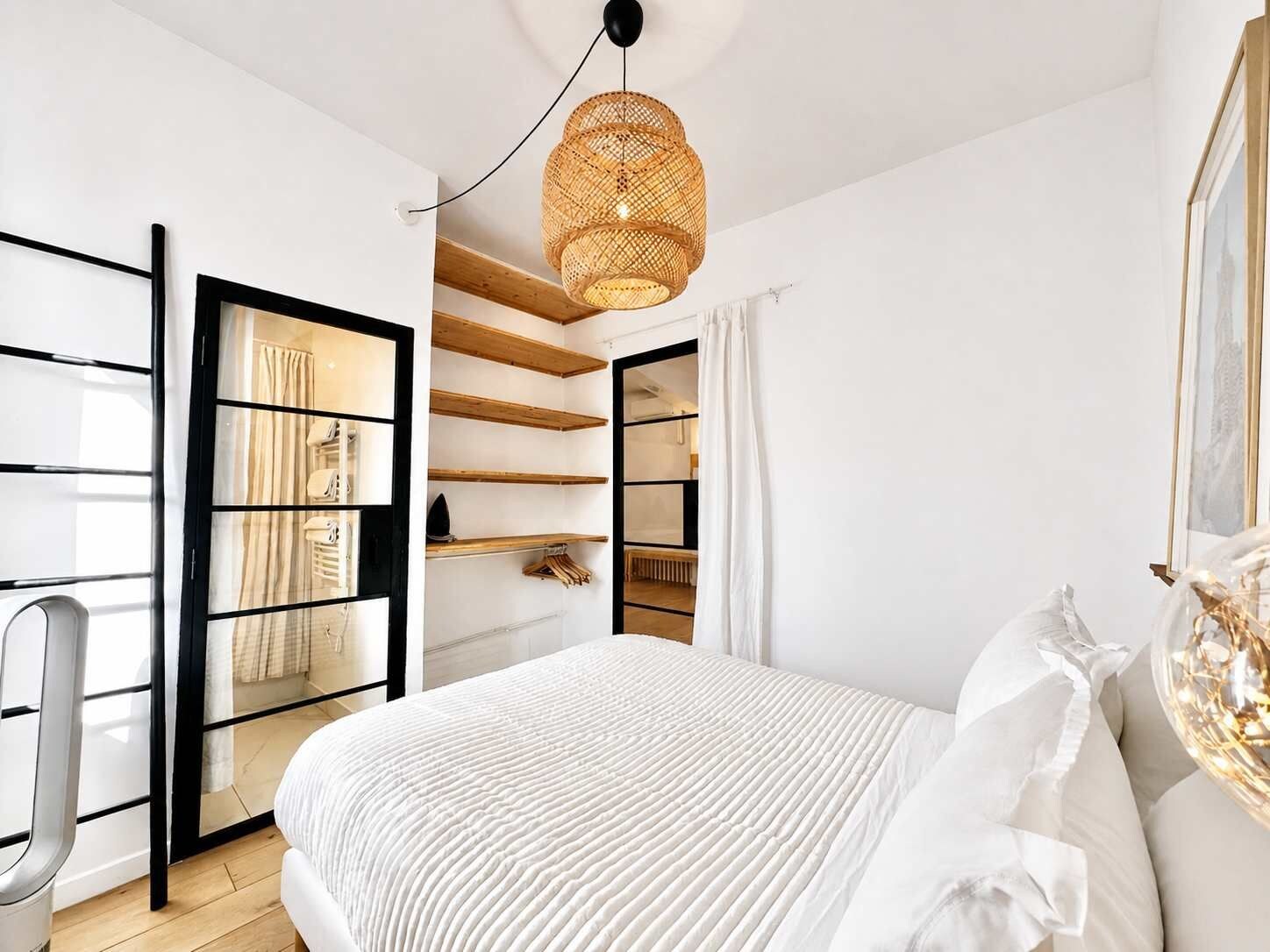 Une chambre à coucher avec un lit, une armoire et un luminaire suspendu.