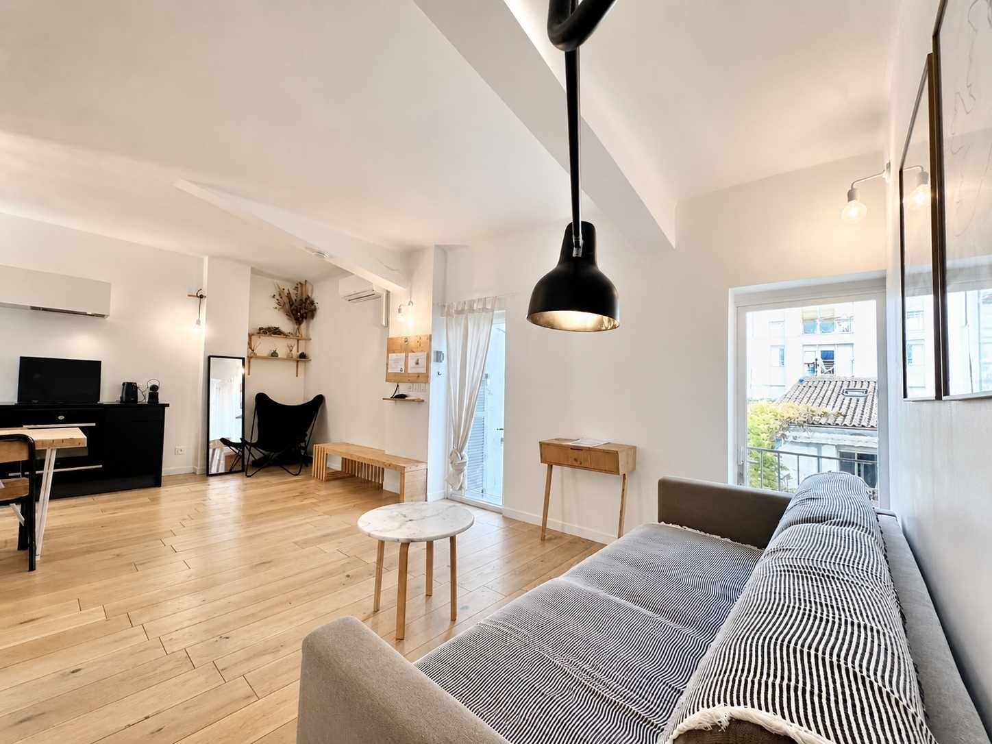 Ein modernes Wohnzimmer mit einer Couch, einem Couchtisch, einem schwarzen Sessel und einem Fernseher.