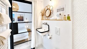 A modern bathroom with a black-framed mirror, white sink, and a towel rack with folded towels. - Ersextius, LMR2, Aix-en-Provence (Aix-en-Provence)