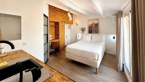 Quarto de hotel com cama, escrivaninha, cadeira e parede de detalhes em madeira.